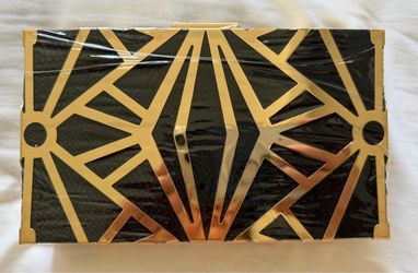 This is a Cariedo Art Deco-style black and gold geometric metal overlay evening clutch featuring a detachable chain strap. Size 8x4 inches