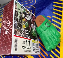 These are Bravest Studios Green Hulk Foot Clogs, featuring a molded green design with an adjustable metal buckle.