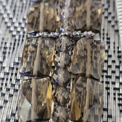 This is a faceted smoky quartz and sterling silver bracelet featuring a box clasp. 