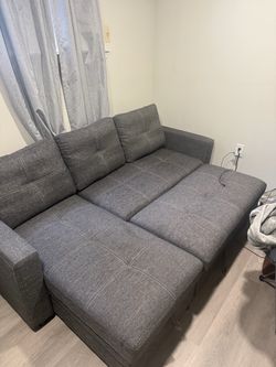 Grey L-shaped/ sofa-bed couch with storage room