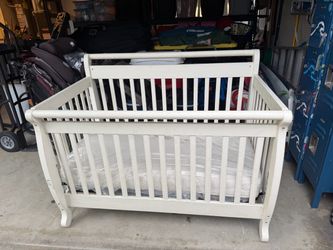 White baby bed with mattress