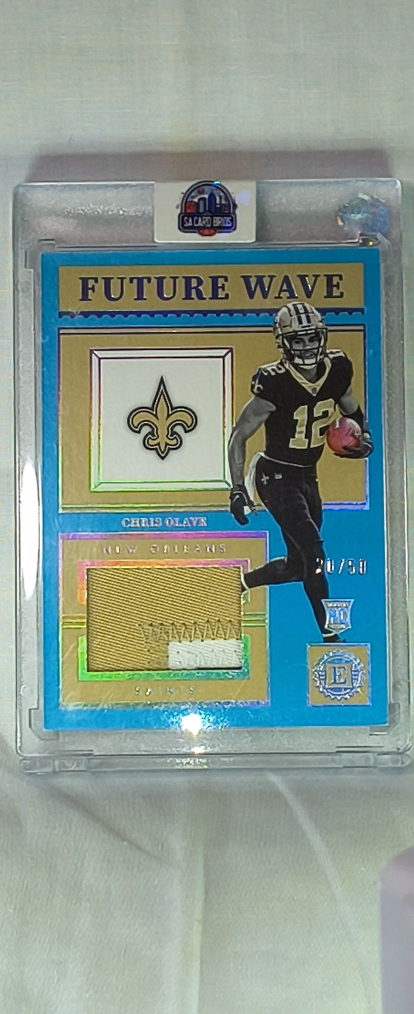 The product is a 2022 Raw Football trading card featuring a Chris Olave Sapphire Future Wave Raw Patch,  This standard-sized card is part of a set fro