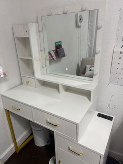 White & gold vanity with mirror Tocador blanco y dorado con espejo.