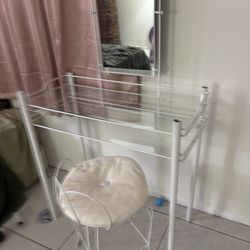 glass vanity with mirror and chair 