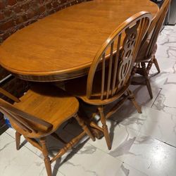 Large solid wood dining table with four chairs