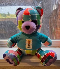 Jazwares FIFA World Cup 2026 Colorful Bear Plush wearing a teal jersey with the FIFA World Cup
