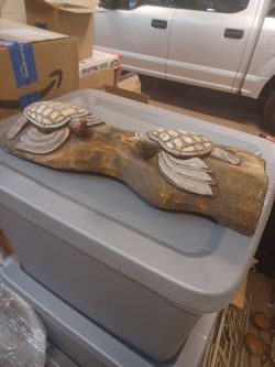 2 wood carved turtles on a wood log