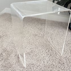 Small clear acrylic side table with waterfall edge.