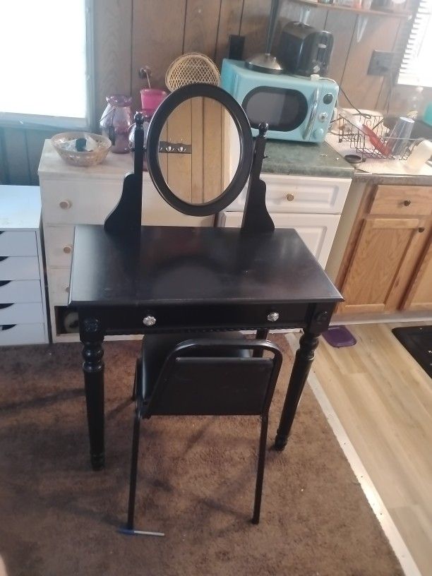 Black Vanity Table With Chair And A TV Stand With Shelves In It