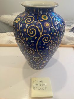 blue Pottery Barn vase featuring a vibrant, multi-colored geometric pattern.