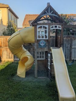 Playhouse with 2 slides, and 2 swings