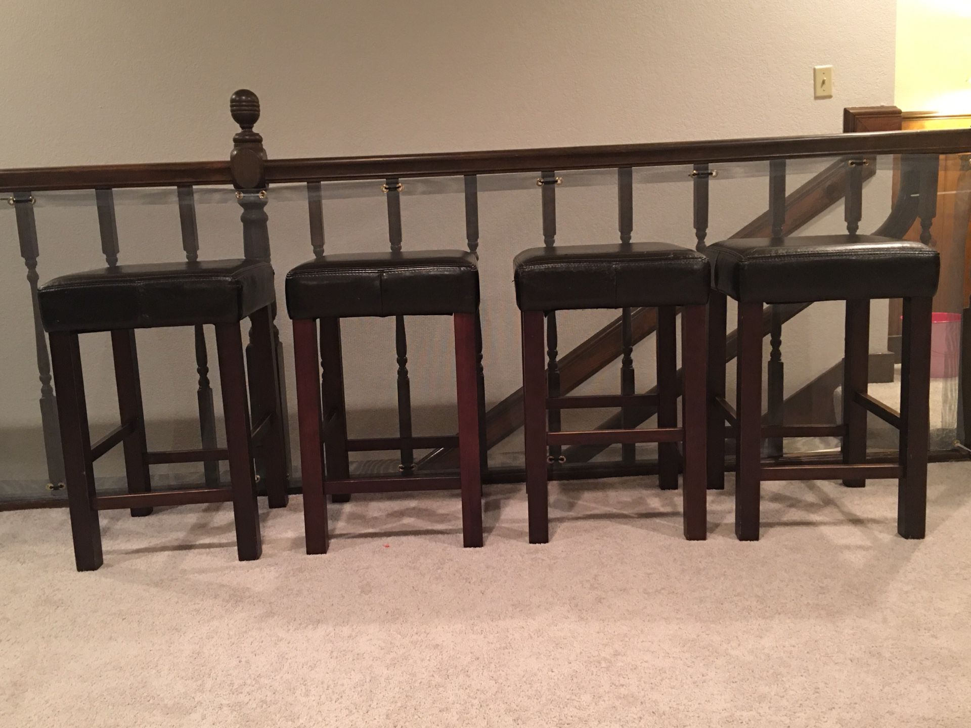 4 black leather stools in good condition