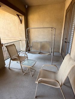 A swing, two chairs, and a glass table