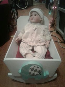 MUNECA. DE PORCELANA. CON LA CUNITA DE MADERA
