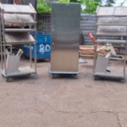 Three adjustable stainless steel food display racks on wheels,