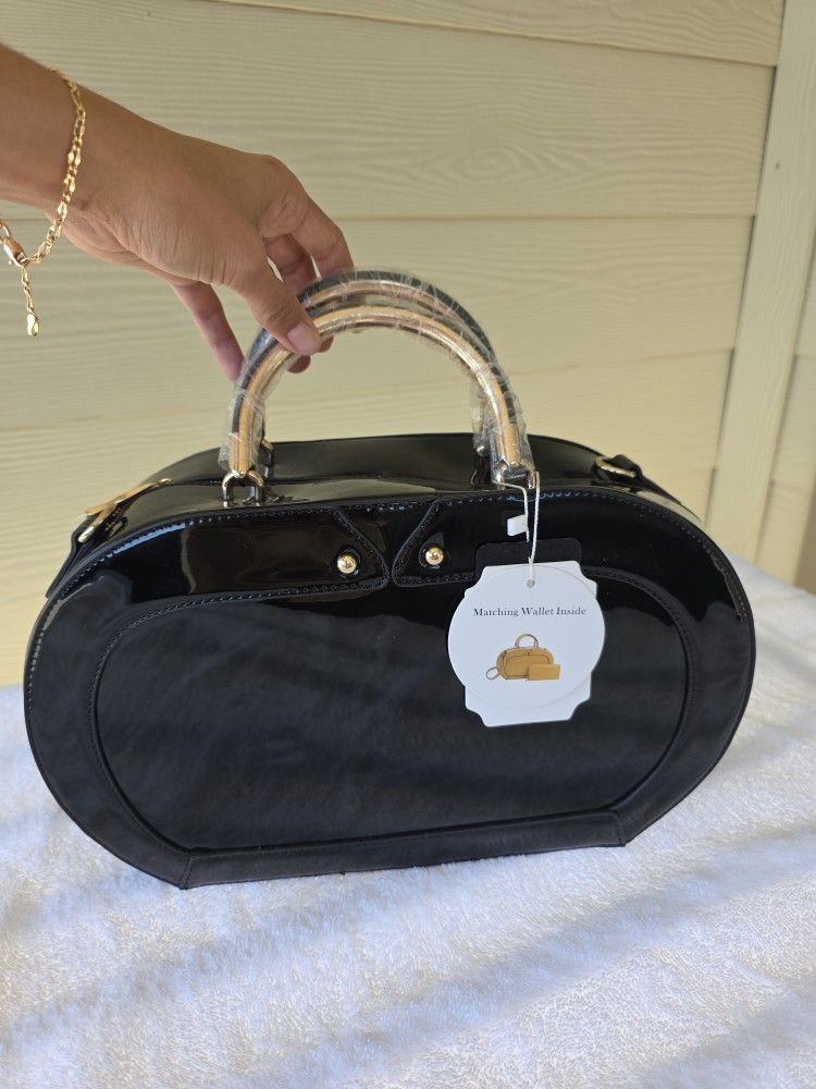 Black patent leather handbag with gold handles and a matching wallet.