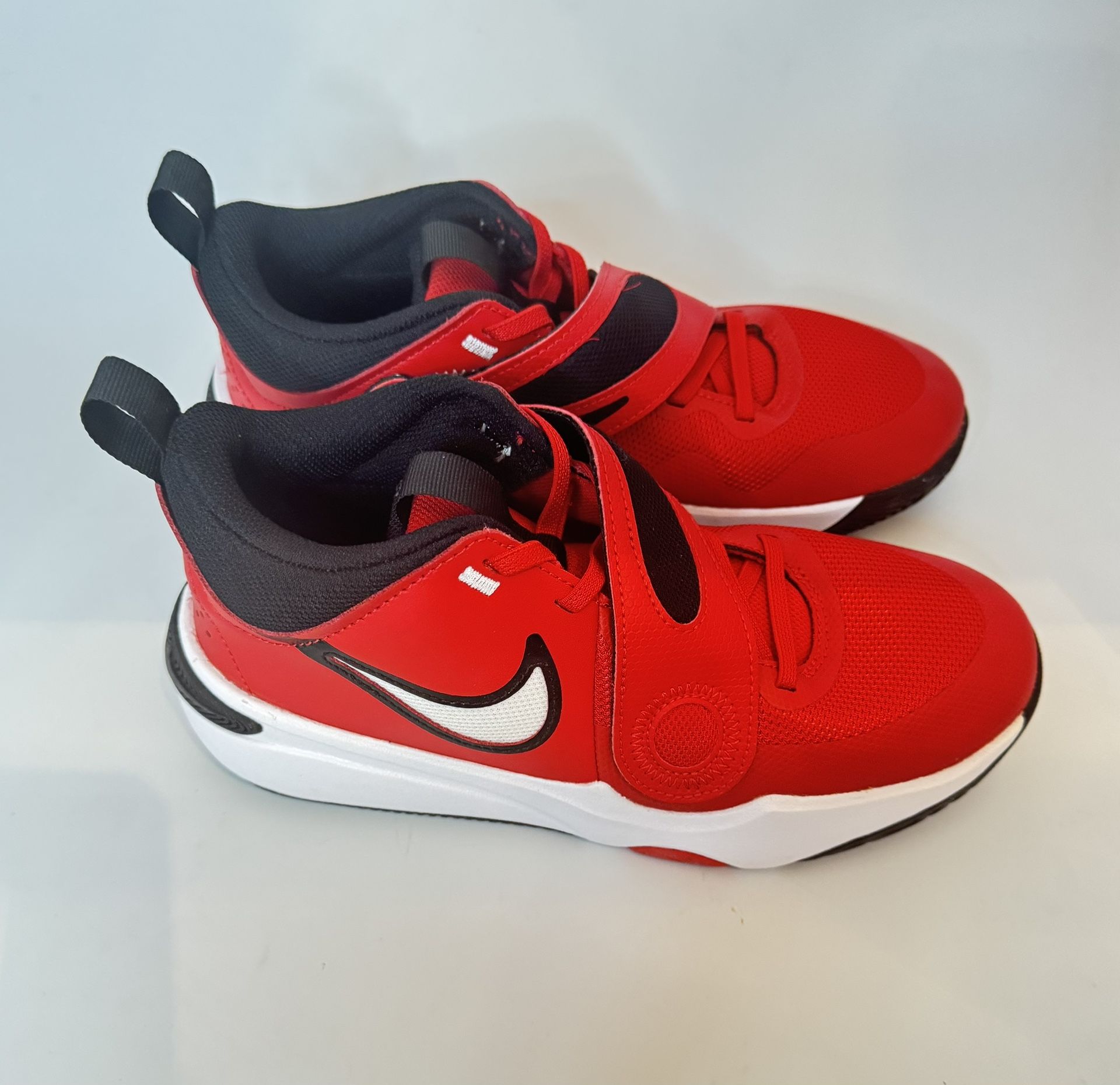 The Nike Team Hustle D 11 Basketball Sneakers in University Red/black/white are designed for boys in size 6Y. These athletic sneakers feature a round 