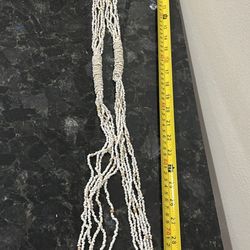 multi-strand necklace made of small white mother-of-pearl or shell beads. 