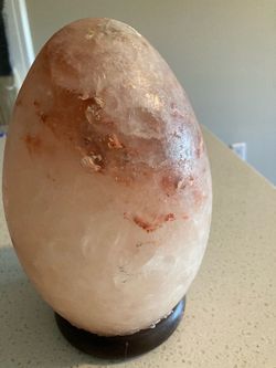 Egg- shaped Himalayan salt lamp with a orange glow
