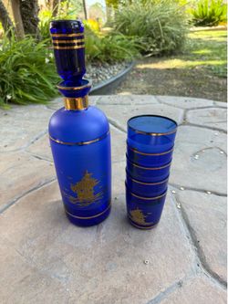 Vintage cobalt blue Venetian art glass decanter set with hand-painted gold ship motifs.
