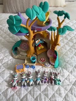 Vintage Fisher-Price treehouse playset with teal leaves and purple platforms. Includes multiple bunny figures and play accessories. Features tree trun