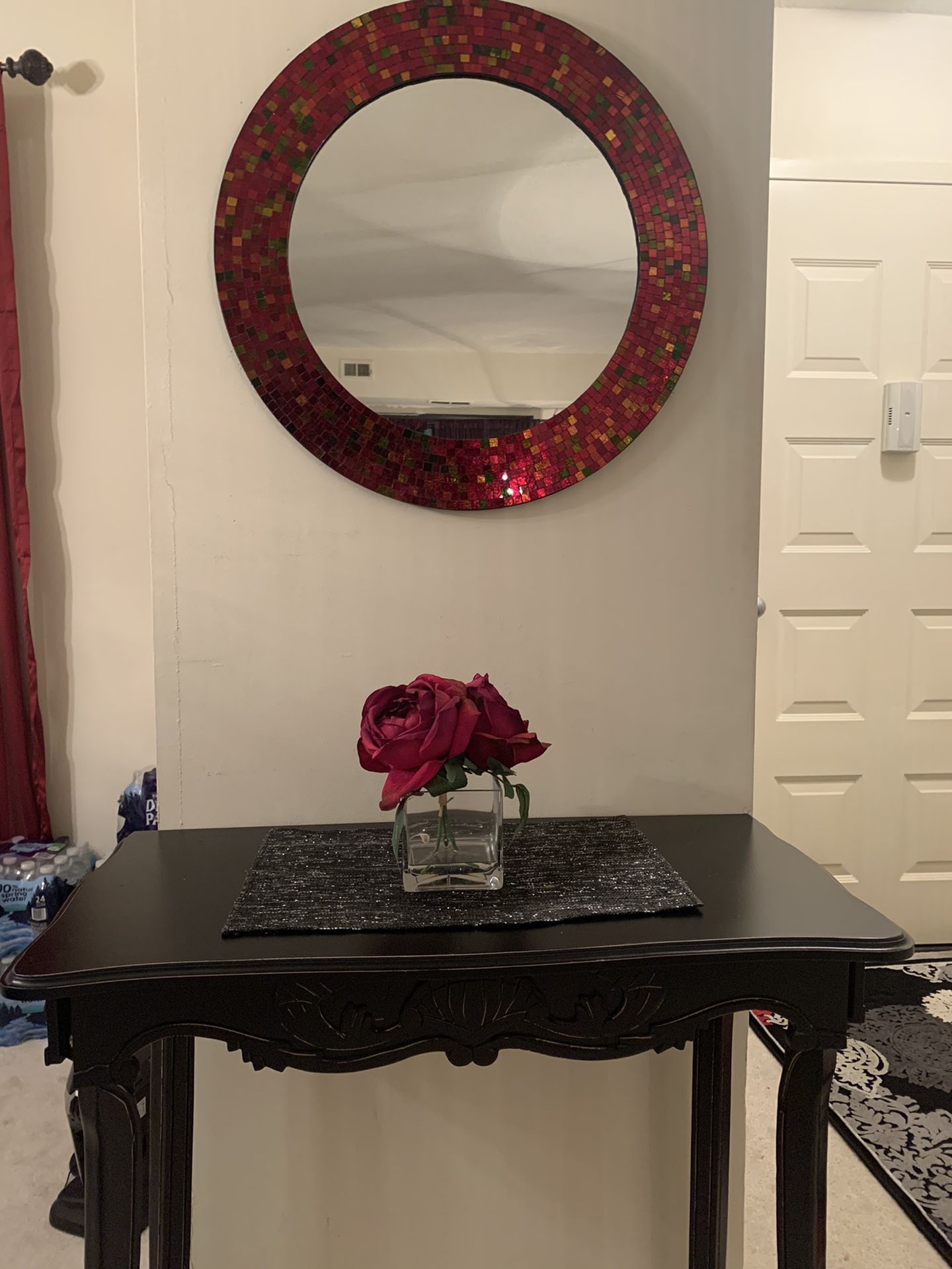 Entry table with a mirror and rug.