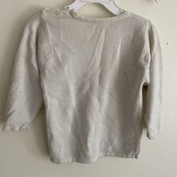 This garment is a knitted long-sleeved top for infants (also known as a baby sweater or jersey top). • Design: This is a round-neck long-sleeved knitt