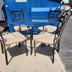 Used 45 "   ROUND GLASS TABLE AND 4 CHAIRS