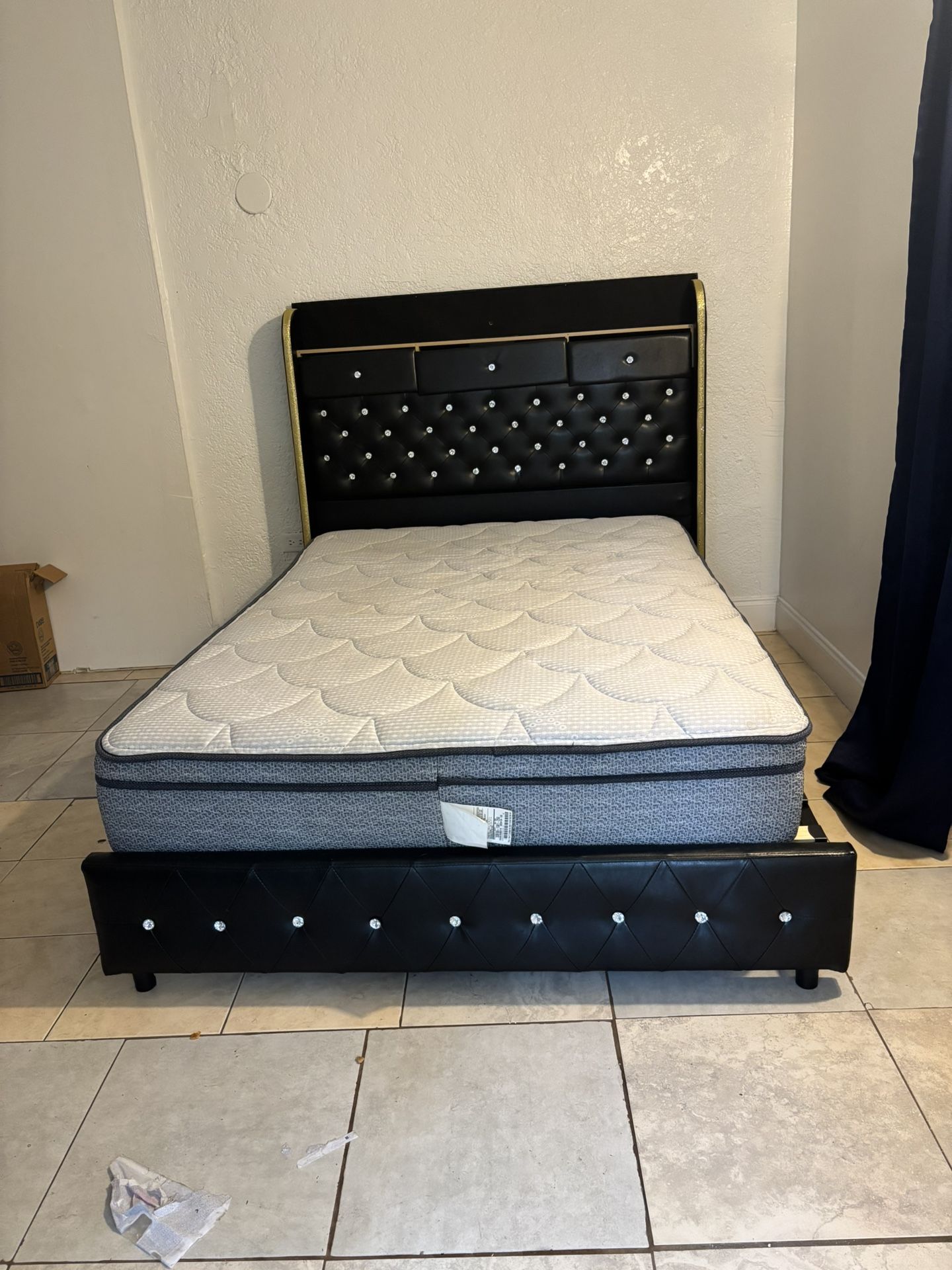 a bed frame with an upholstered headboard and a mattress.