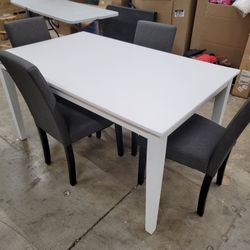 White table with 4 gray upholstered chairs. 
Corner of table has some minor cosmetic flaws as pictured.
Table 59x35x30"

$300 set
 FIRM