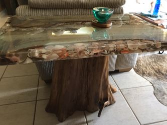 Table. Handmade shell table sitting on Cypress stump