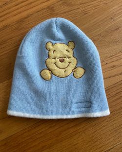 Idle Winnie the Pooh baby/child warm knitted hat. The light blue color complements the skin tone well. There are signs of normal use and slight fuzz o