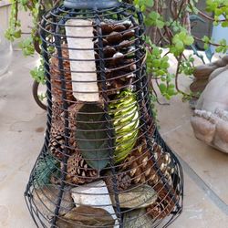 $12 Metal Garden Lantern Filled with Pinecones and Other Decor. You can empty it and add a Candle 