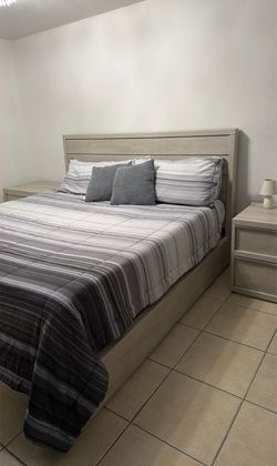 Cama king size con su colchón y dos mesas de noche a juego
