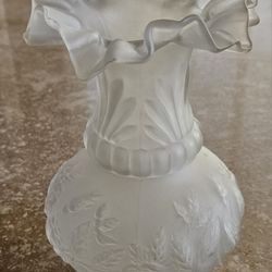 Vintage frosted glass vase has raised flowers and leaves design on body and ruffled rim. 7-3/8" tall x 5" diameter at top and 4-1/4" diameter at wides