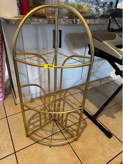 gold-tone metal corner shelf features an Art Deco