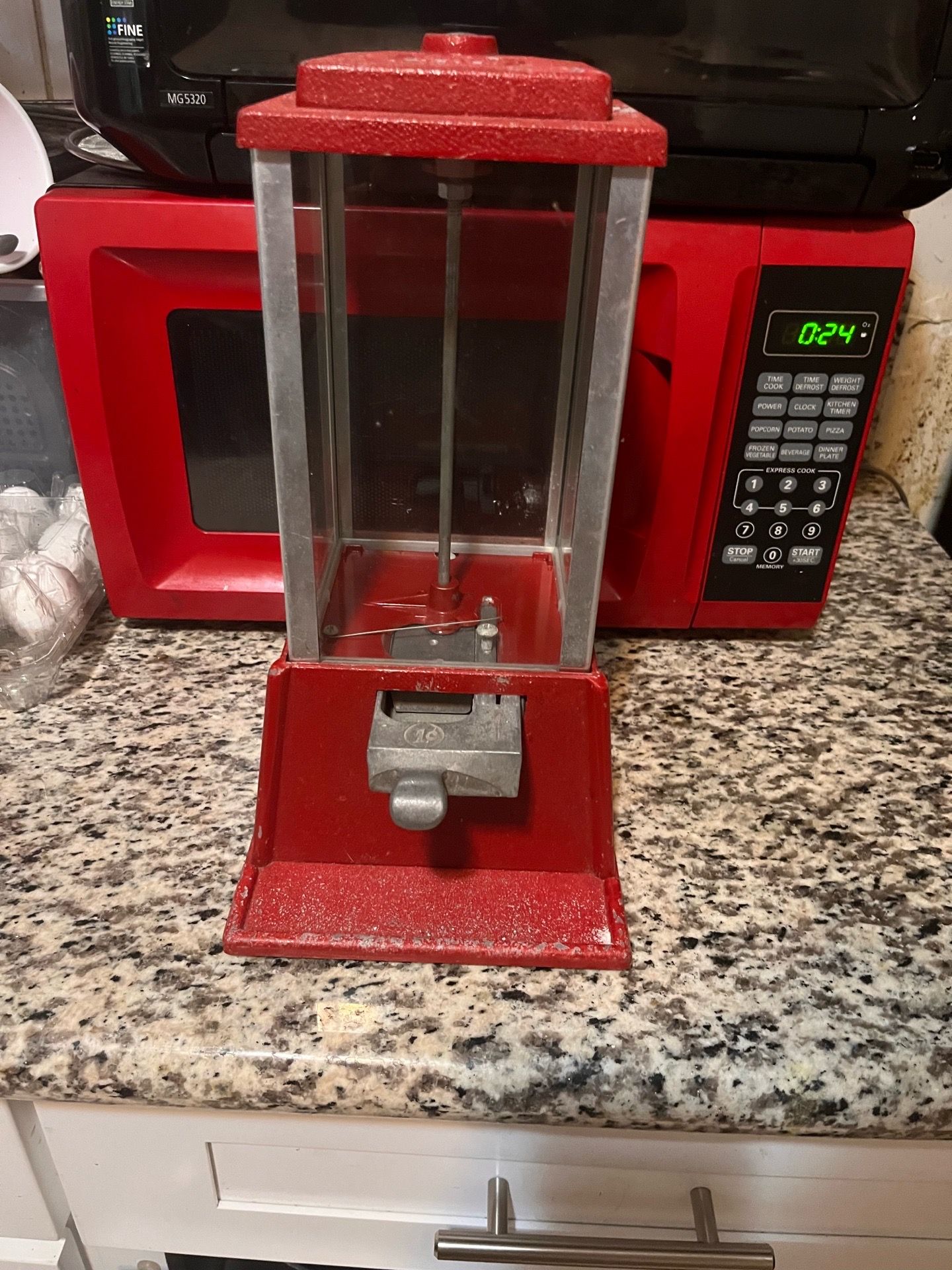 style red gumball vending machine, likely produced in the 1950s or 1960s