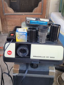 Leitz Pradolux RT-300 is a classic 35mm slide projector notable for its Kodak tray compatibility, high-end Leitz optics, and side-access lamp housing 