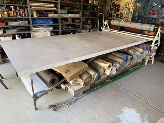 Large industrial metal cutting table with roll holder