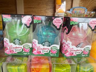 New squishy sensory toys in the shape of a drink cup. Each item is made of a soft, glittery material and comes in green, blue, or pink. The brand is N