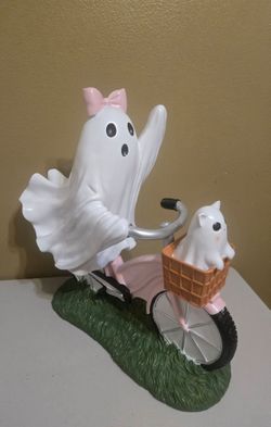 Giant pink ghost girl on bicycle