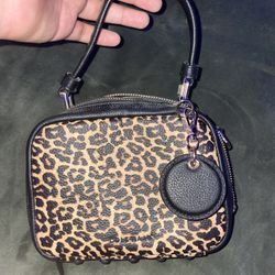 This is a Cole Haan Mini Boston Bag in leopard print and black pebbled leather 