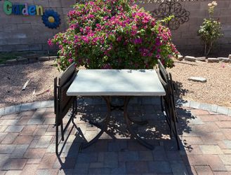 Set of 2 ratan brown patio bistro stackable chairs and a square table.