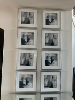Set of square framed abstract art prints featuring deep navy blue, charcoal gray, and white abstract brushstrokes set behind white matting in brushed