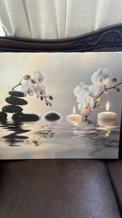 Tranquility picture with candles, rocks, and orchids and water