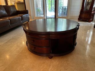 Large, round center coffee/TV table with drawers and side cubbies