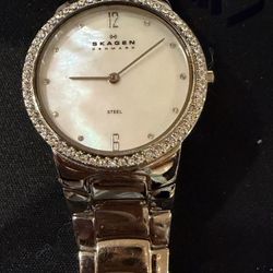 1. Skagen women's watch with a crystal-accented bezel and a mother-of-pearl dial, stainless steel bracelet band and is a classic, dress-style timepiec
