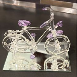 This hand-blown/spun glass bicycle figurine on a bevel-edged mirror base