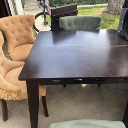 Dark wood dining table with green and beige chairs