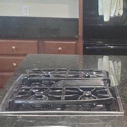 GE gas cooktop with fan in middle